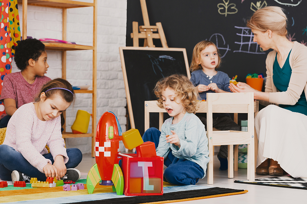 Children playing in a daycare with caregiver.