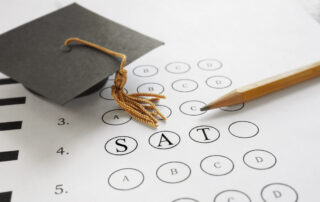 SAT test with pencil and mortar board graduation cap